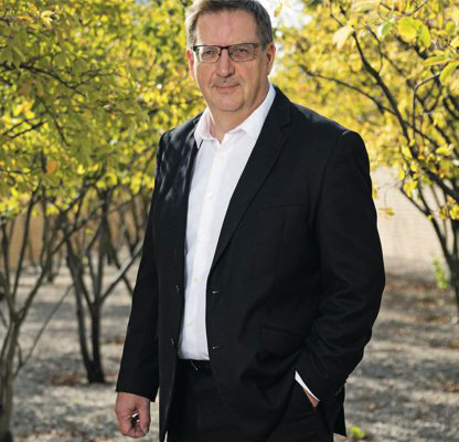 Ivo Elkuch steht zwischen Bäumen im Freien